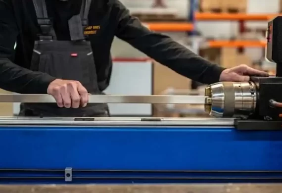 Medewerker van Veldkamp RVS die een RVS buis of profiel positioneert en bewerkt op een draaibank of bewerkingsmachine, gericht op nauwkeurige maatvoering en afwerking.