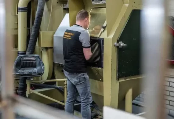 Medewerker van Veldkamp RVS die een RVS onderdeel straalt in een straalcabine, voor het reinigen en voorbereiden van het oppervlak op verdere afwerking.